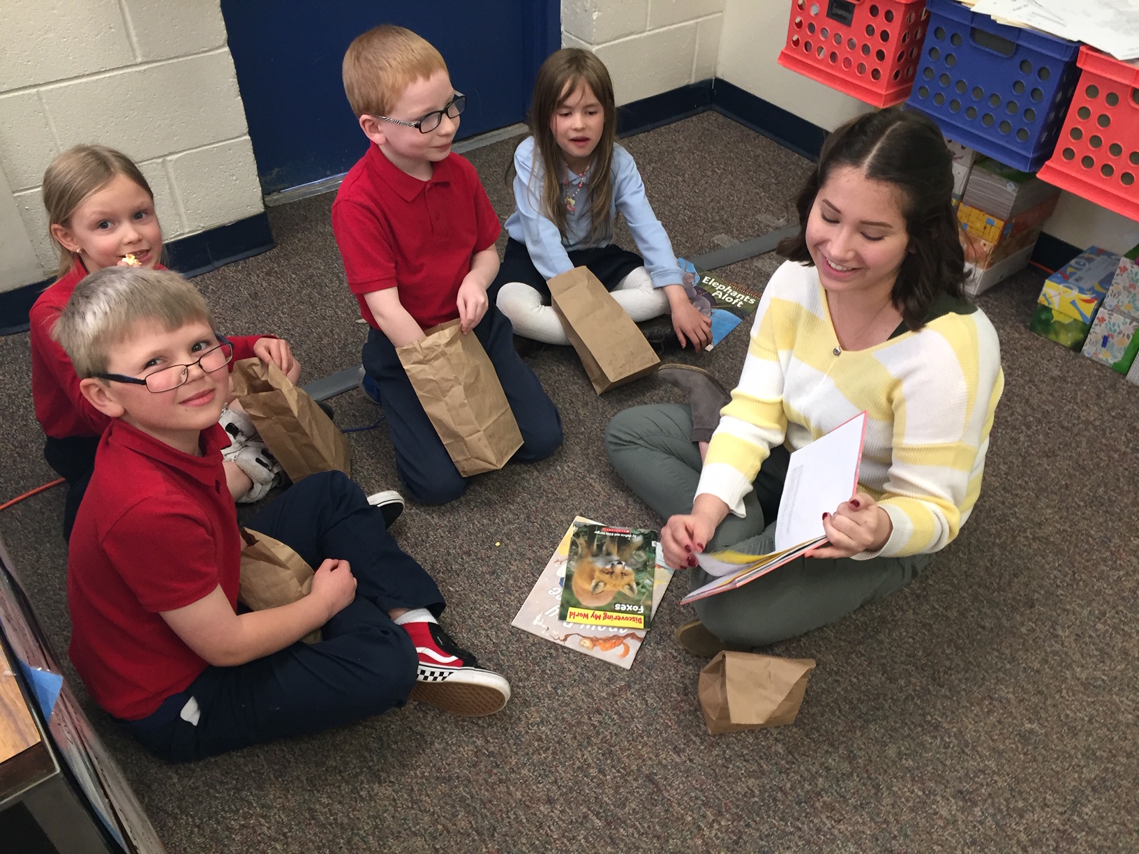 The Vanguard School Teacher reads to hear kindergarten students sitting on the floor in a semi-circle