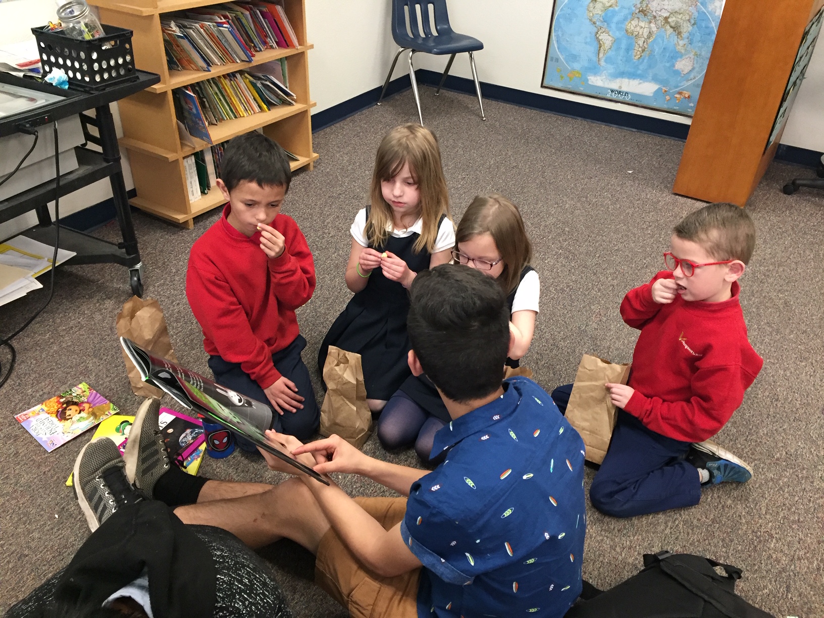 Kindergarten students at The Vanguard School sitting in a circle reading a book.