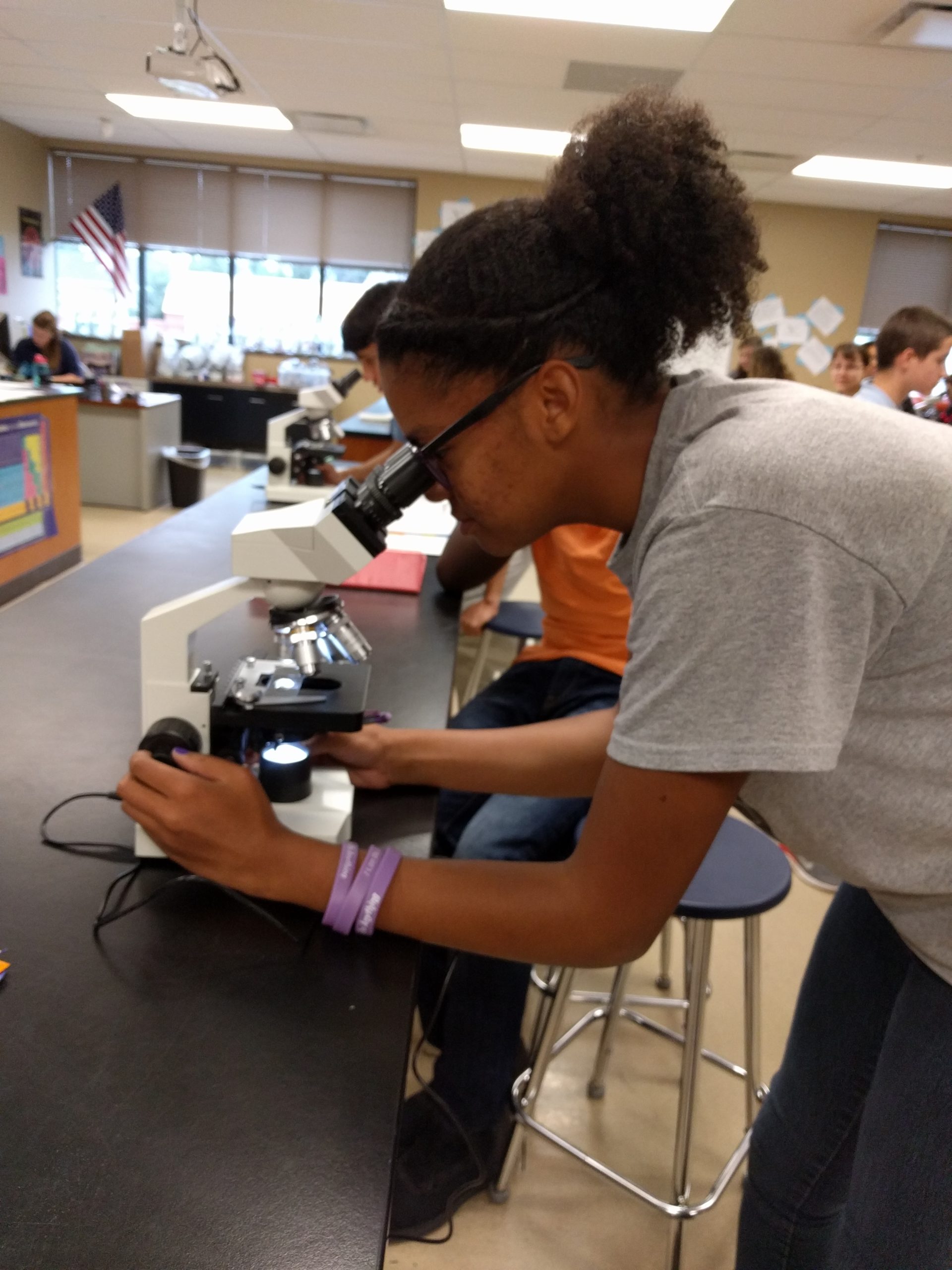 A Vanguard student using a microscope in science lab