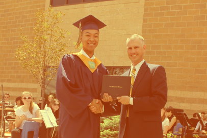A Vanguard graduate shaking hands with the dean of the school on graduation day